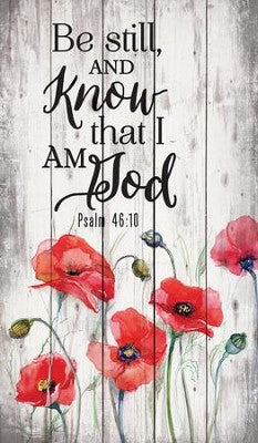 Wall art displaying "Be Still and Know" text in simple typography against a neutral background and red flowers