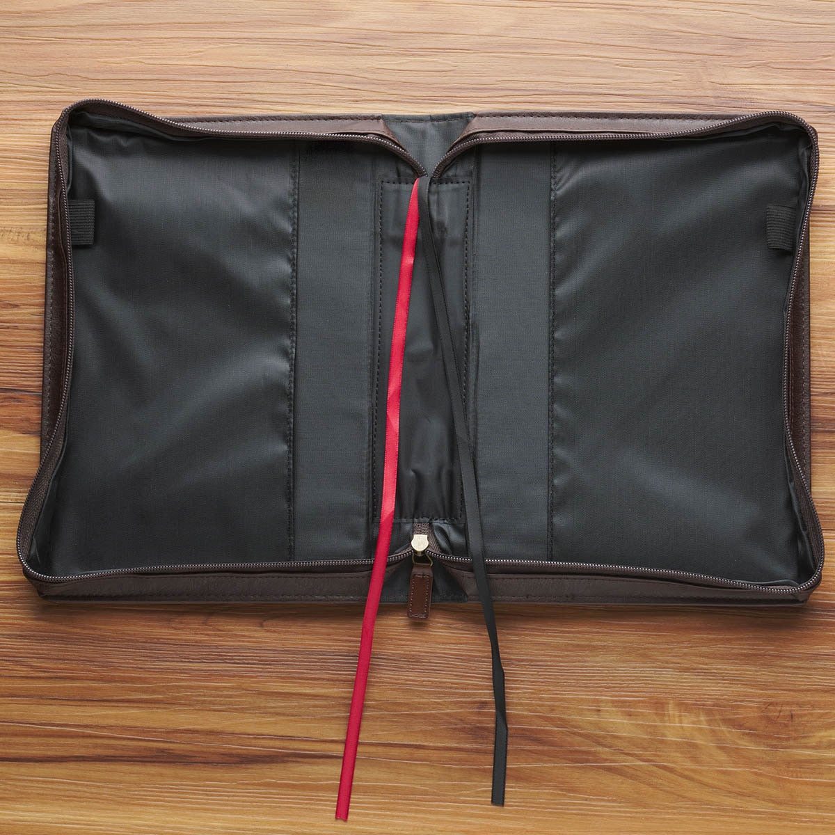 Open brown Crown of Thorns Bible cover with red and black ribbon markers and pen loops