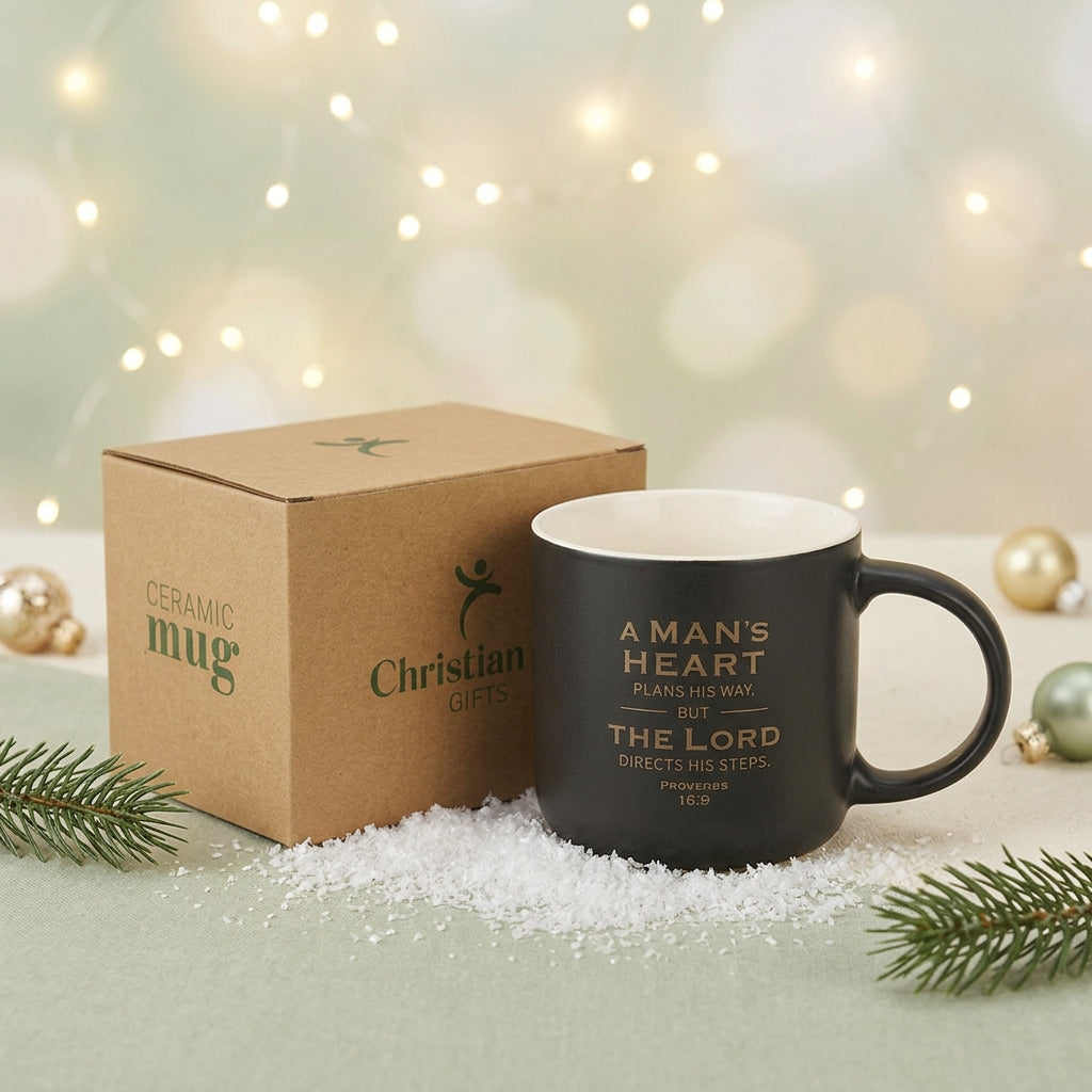 A Man's Heart mug beside its kraft gift box, evergreen branches and Christmas ornaments.