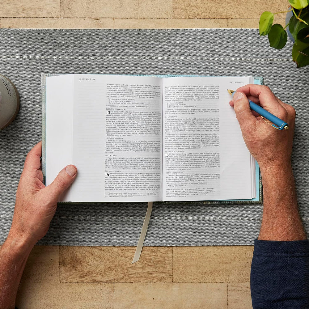 Open NKJV Journal the Word Bible on a table, showing lined note-taking margins beside Scripture.