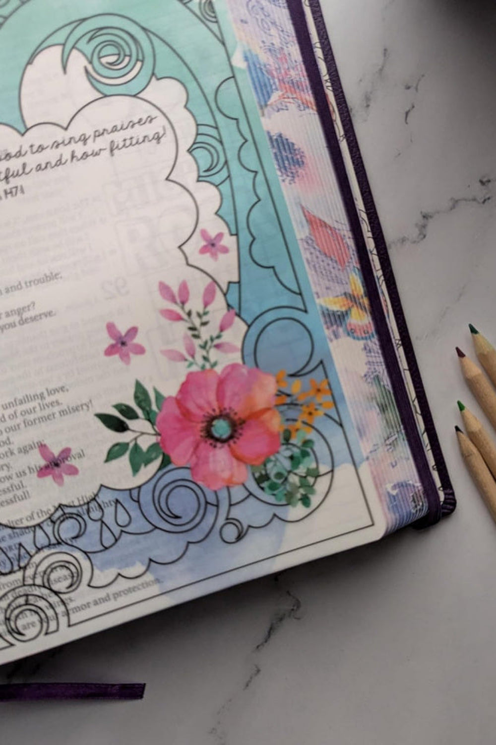 Close-up of a colored floral Scripture illustration in the NLT Inspire Praise Bible.