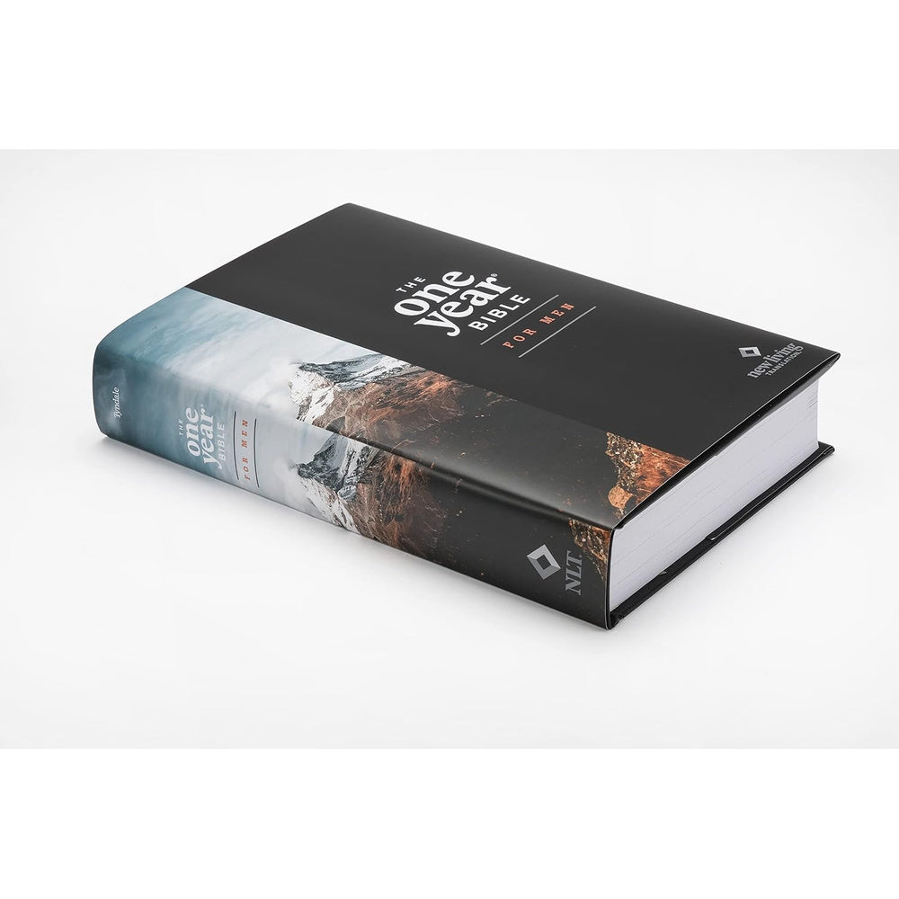 NLT The One Year Bible for Men lying closed on a pale tabletop, showing its mountain cover and page edges.